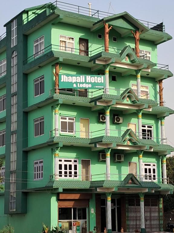 a green building with a sign on it at Jhapali Hotel and lodge in Simra