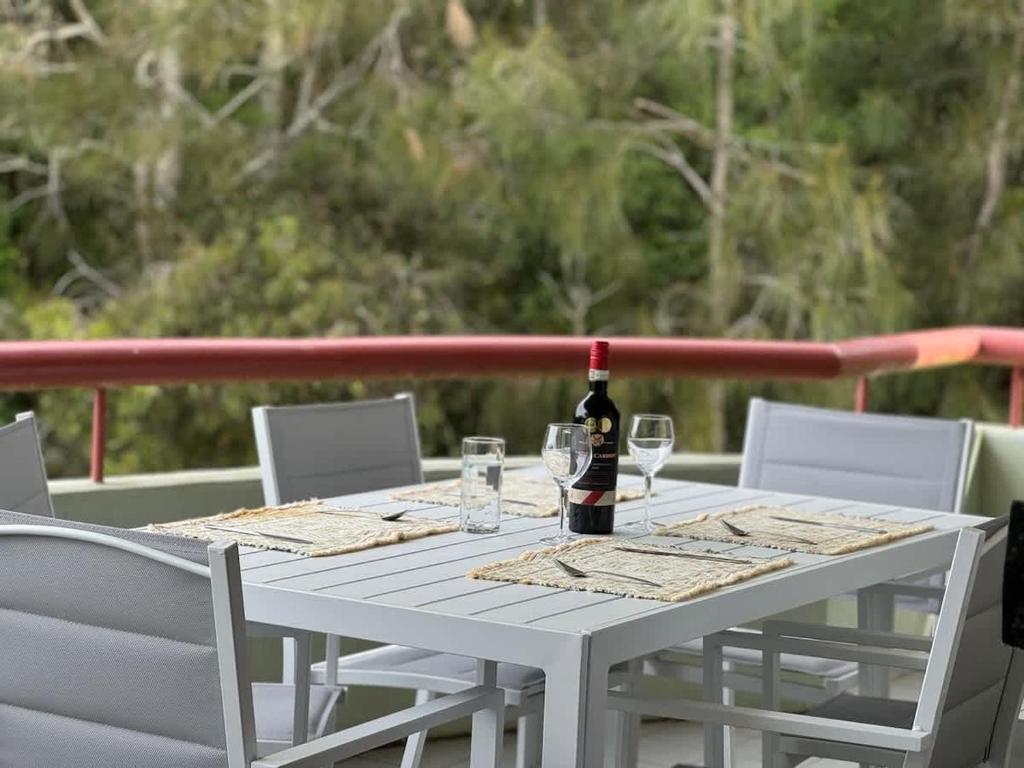 a white table with a bottle of wine and glasses at Fathoms 5 - 2BR beach resort apartment in Mollymook