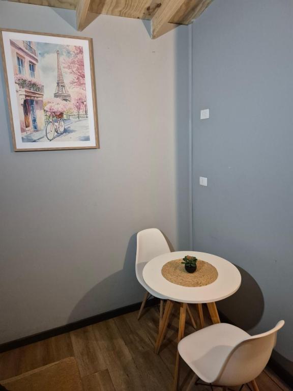 a table and chairs in a room with a picture at Cabañas don jose 1 in Pucón