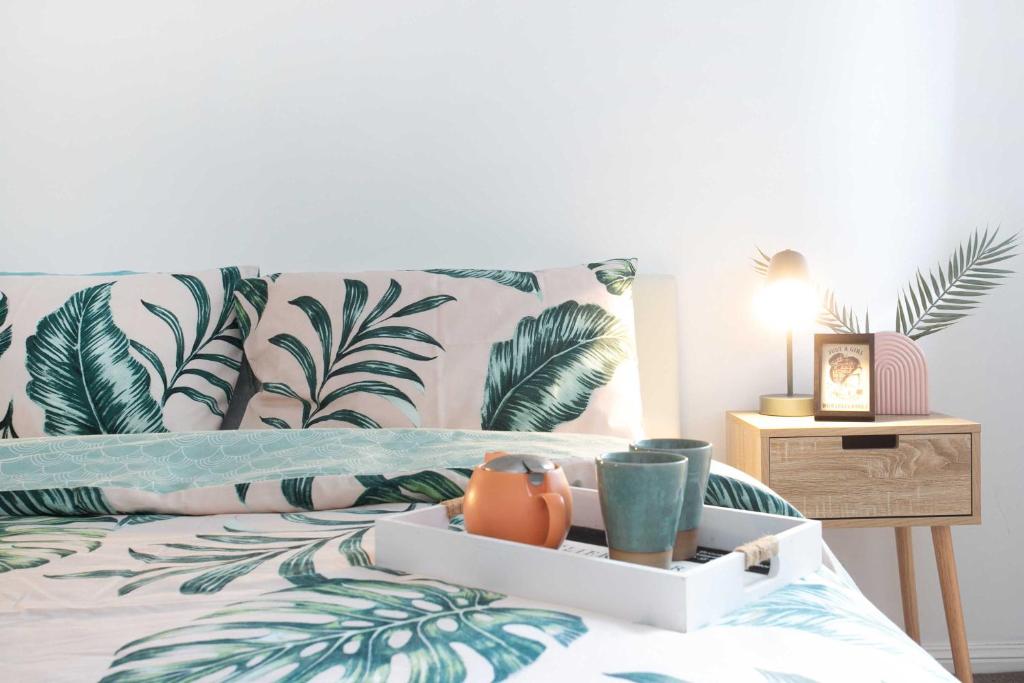 a bedroom with a bed with a tropical wallpaper at The Salty Deck in Narrawallee