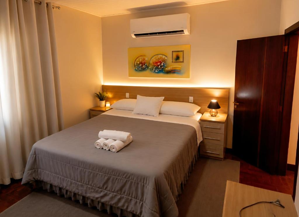 a bedroom with a bed with two towels on it at Flat Completo - Cozinha - Lavadora - Climatizado in Erval dʼOeste