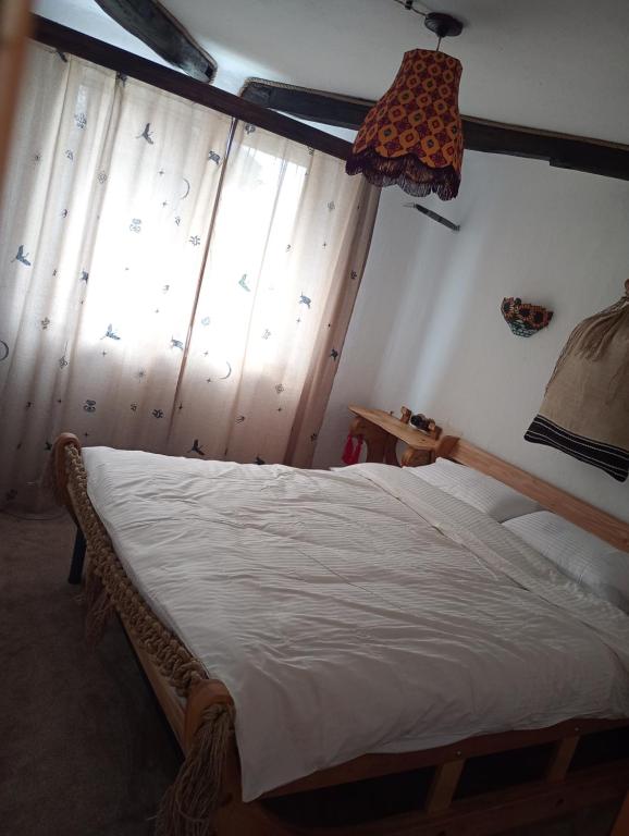 a bedroom with a bed in a room with a window at Глинобитні будиночки in Darakhov