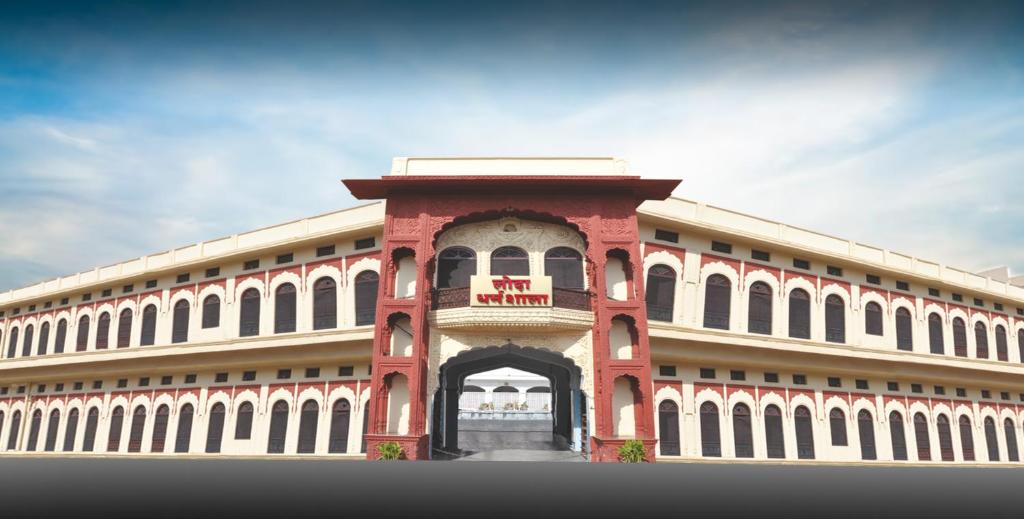 a large red and white building with a balcony at Lodha Heritage in Ajmer