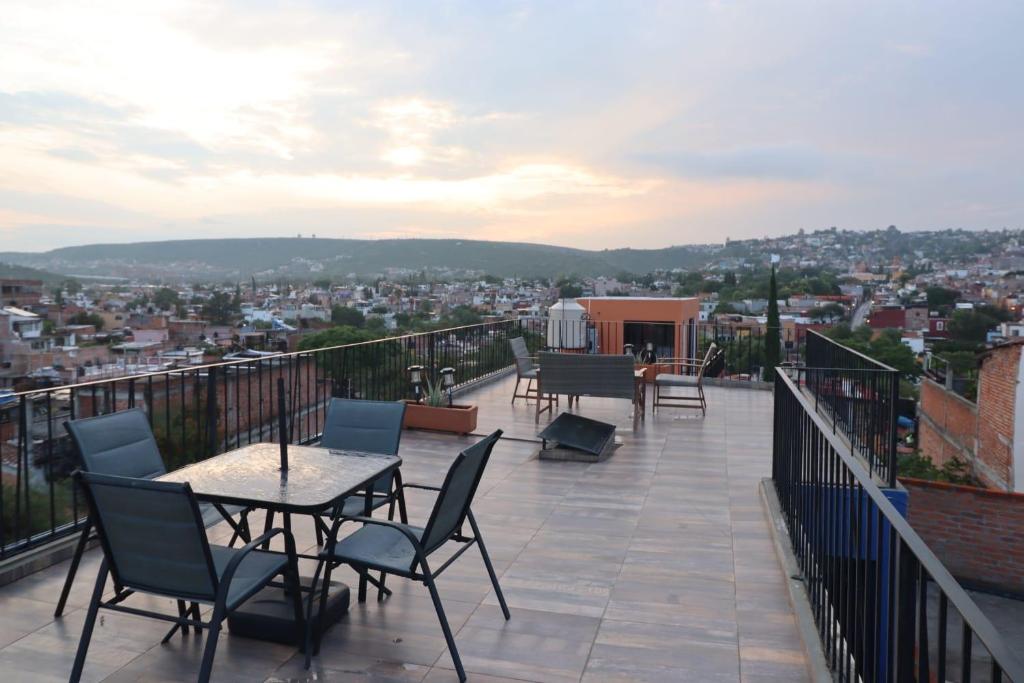 a patio with tables and chairs on a balcony at Casa El Arte De Frida in San Miguel de Allende