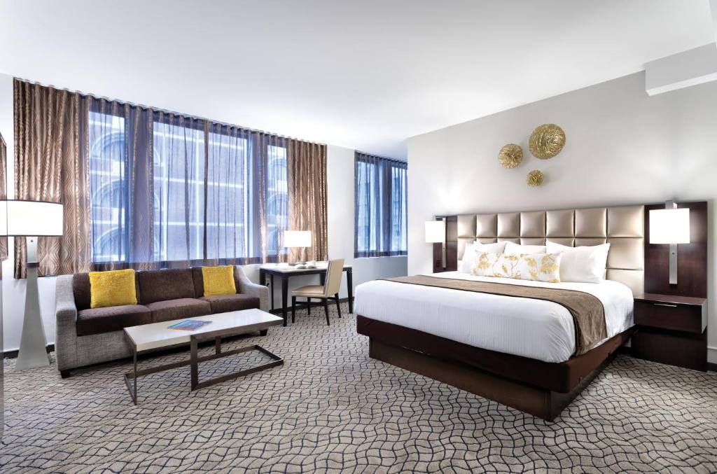 a hotel room with a bed and a couch and a desk at The Donatello Resort Studio Apartment in San Francisco