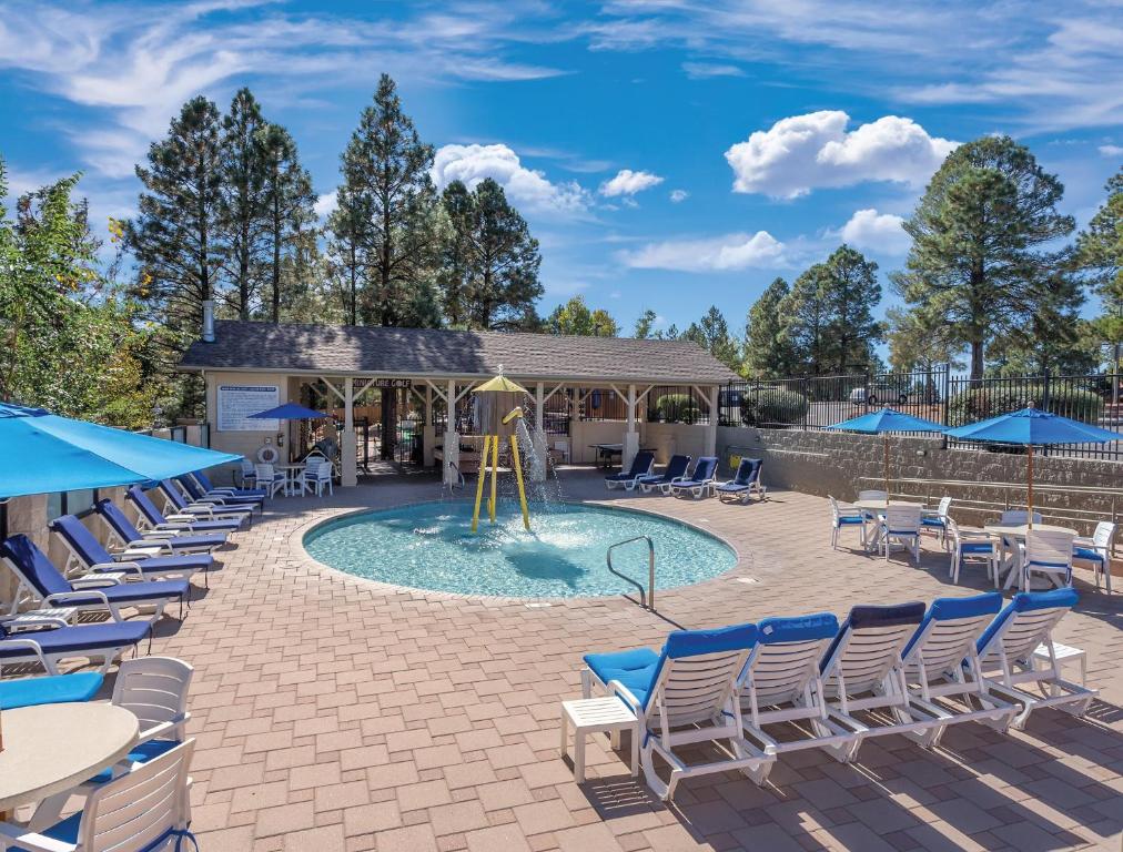 a swimming pool with chairs and a playground at Flagstaff Resort 2BR Apartment in Flagstaff