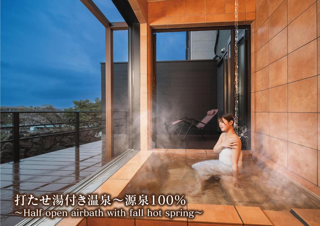 a woman sitting on the balcony of a house at みたまの湯宿 in Beppu