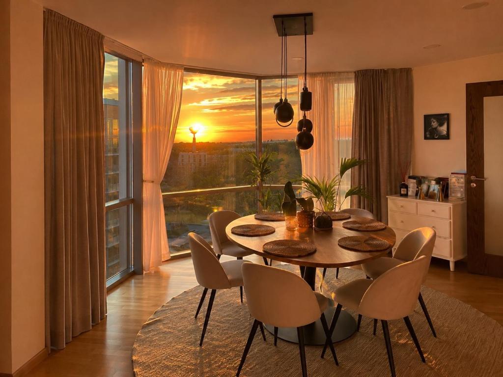 a dining room with a table and chairs and a window at ToVa Apartamentai in Šventoji