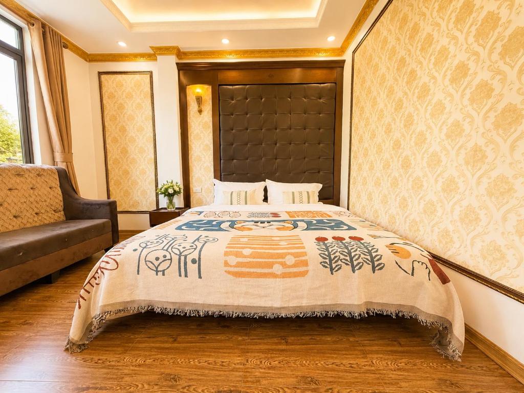 a bedroom with a large bed and a couch at Giang Ninh Hotel - Korean Town Bac Ninh in Bồ Sơn