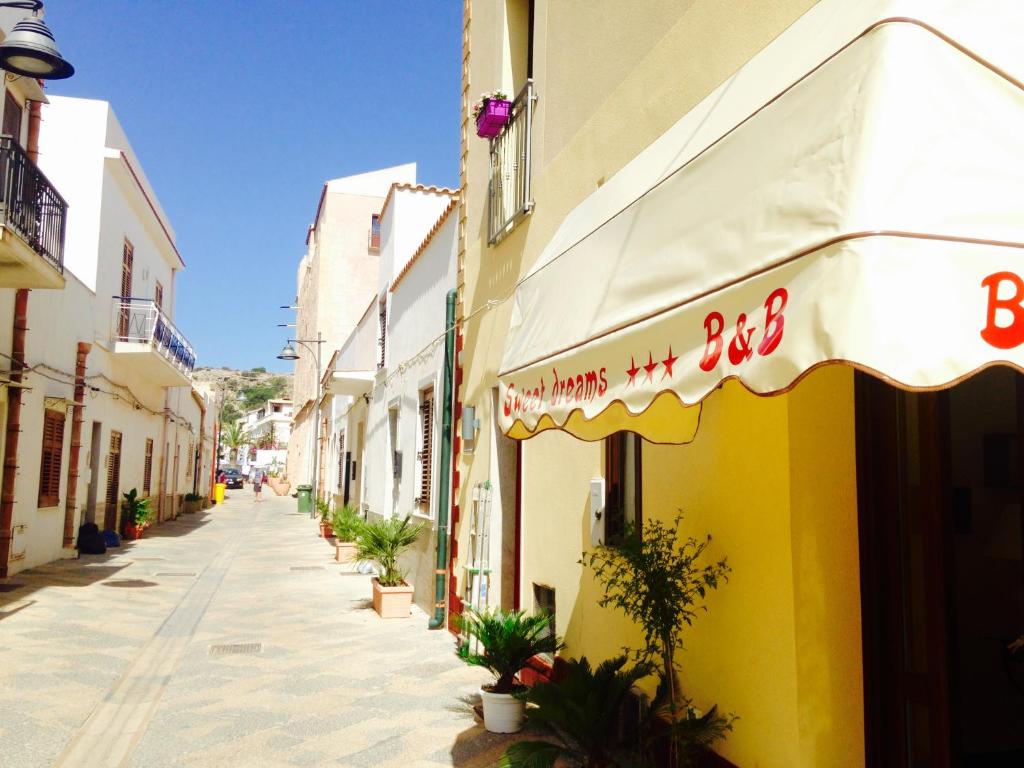 a street with a building with a sign on it at Sweet Dreams in San Vito lo Capo