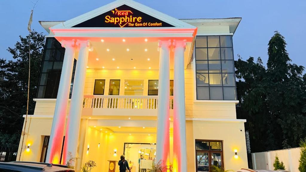 a large white building with columns in front of it at Hotel Red Sapphire Kushinagar in Kushinagar