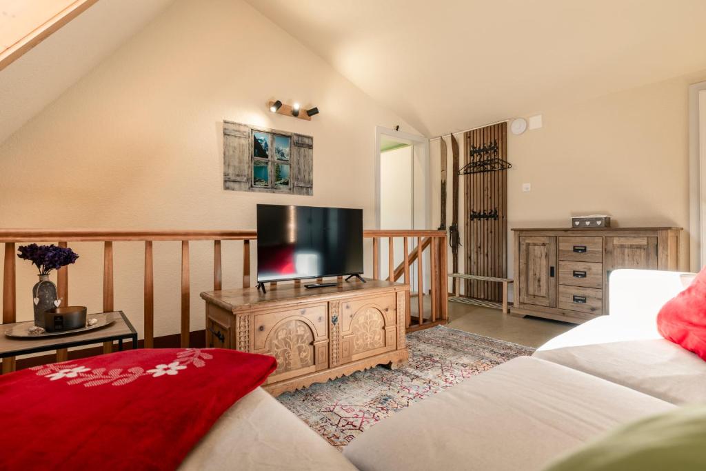 a living room with a flat screen tv on a wooden cabinet at Steinbockblick Maienfeld in Maienfeld