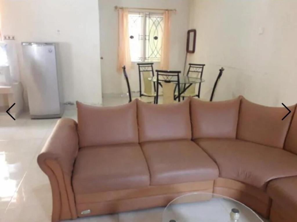 a living room with a brown couch and a table at Villa Venesia Berastagi Resort in Berastagi