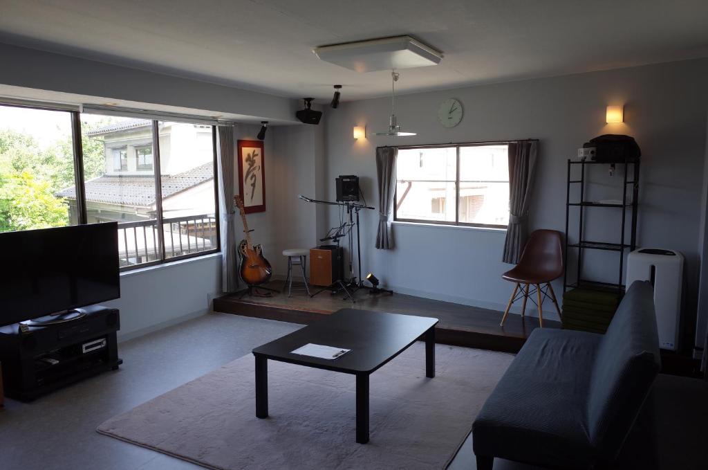 a living room with a couch and a table at カルフールゲストハウス別館 in Toyama