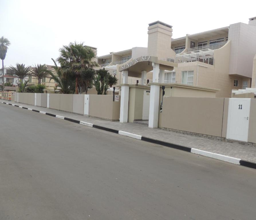 a building with a fence next to a street at Sand and Sea 25 in Swakopmund