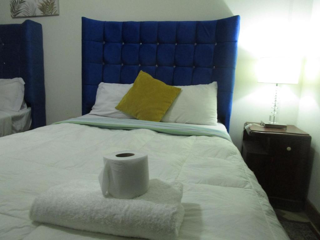 a bed with a blue headboard and a pile of towels at jazmines point in Lima
