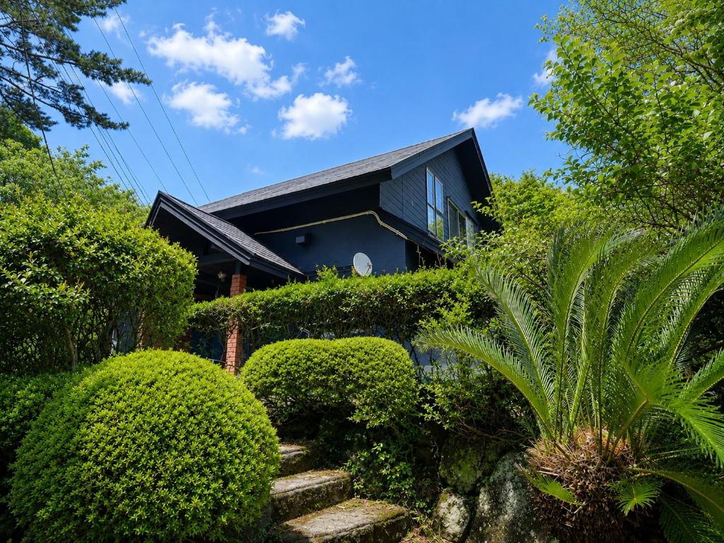 a house with bushes and stairs in front of it at rinne 伊豆 Private Spa in Ito