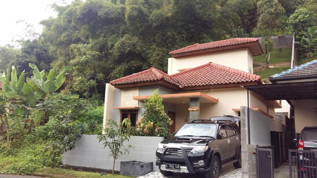 un coche aparcado frente a una casa en Villa Roemi, en Bandung