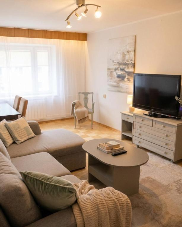 a living room with a couch and a flat screen tv at Vabaduse Apartment - külaliskorter Kärdlas in Kärdla