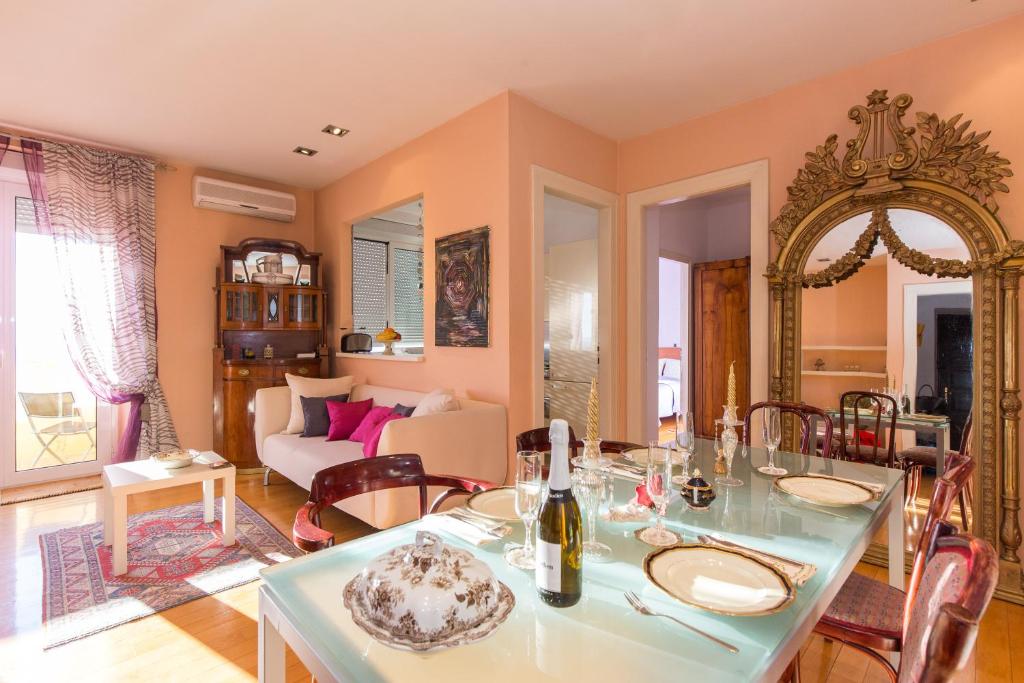 a dining room with a table and a living room at Apartment Arcadia in Rijeka