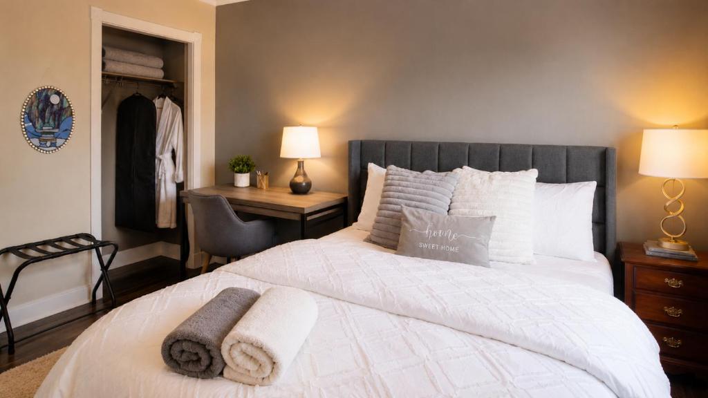 a bedroom with a large white bed and a desk at Tuscan Ridge Guesthouse Calgary West in Calgary