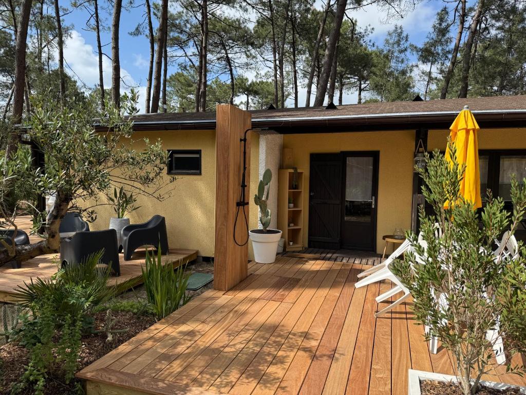 a house with a wooden deck in front of it at Euronat naturist studio in Grayan-et-lʼHôpital