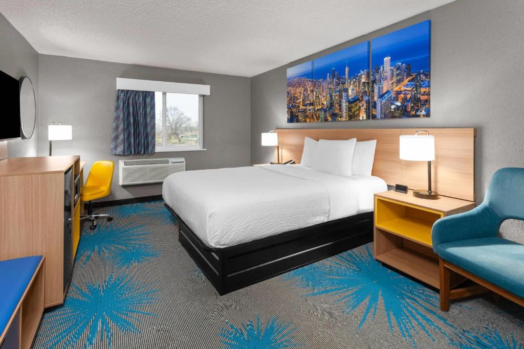 a hotel room with a bed and a chair at Days Inn by Wyndham Waukegan Great Lakes-Free Breakfast and Naval Base Shuttle in Waukegan