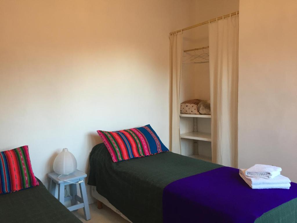a bedroom with two beds and a mirror at Alojamiento en Tilcara in Tilcara