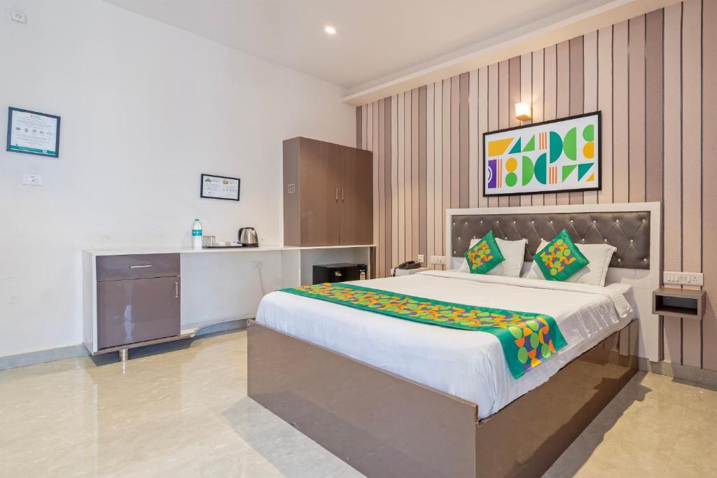 a bedroom with a large bed and a kitchen at Treebo Imperia, Kommadi in Visakhapatnam