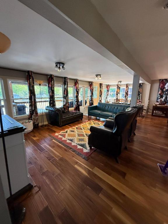 a living room with a couch and chairs and windows at Rising Sun Rustic Retreat in Roach