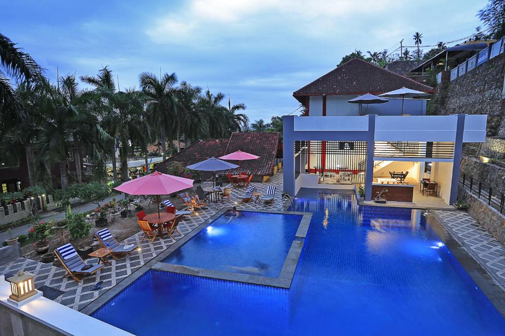 an overhead view of a swimming pool with chairs and umbrellas at Jazz Senggigi Hotel in Senggigi
