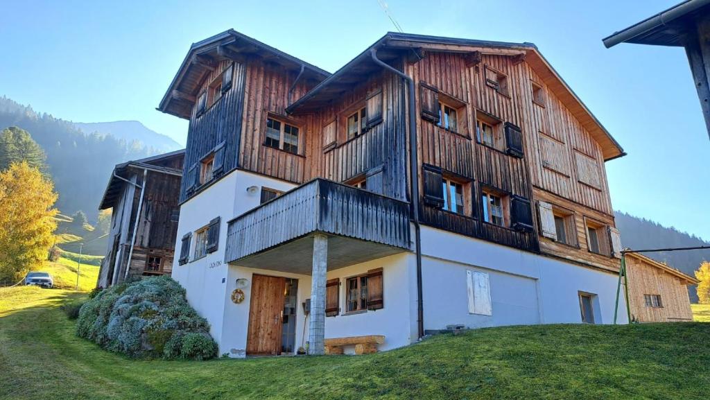 a large wooden house on top of a hill at Casa Runs 7113 Camuns, Val Lumnezia in Furth