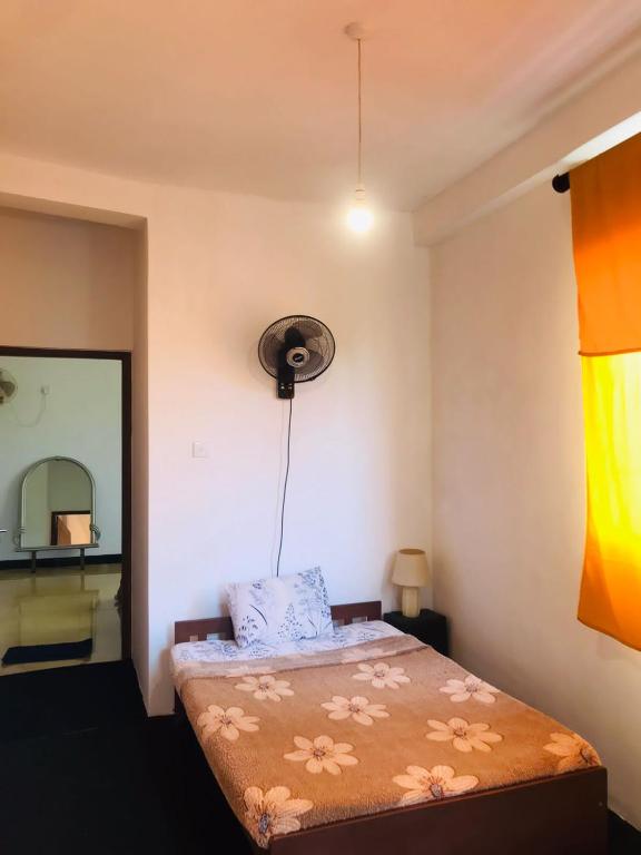 a bedroom with a bed with a mirror and a fan at Bevibe kottawa in Kottawa