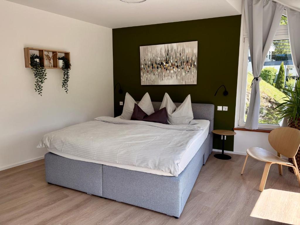 a bedroom with a bed and a green wall at FEWO Studio7 in Vorderelsenwang
