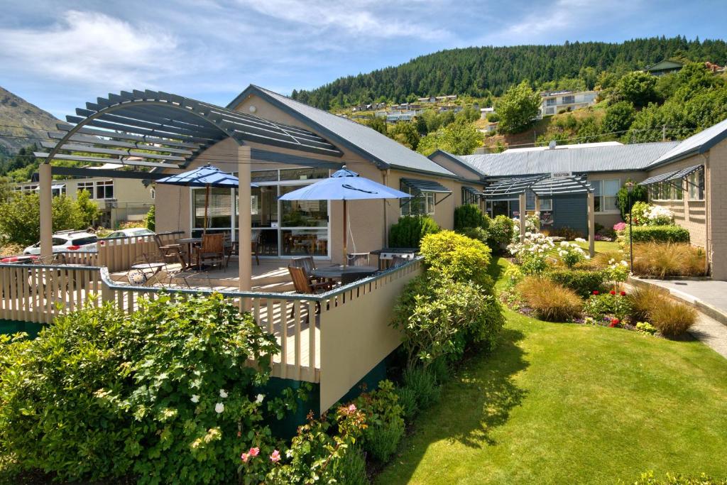 a house with a deck with an umbrella at Melbourne Lodge in Queenstown