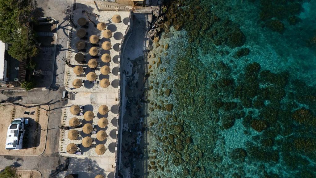 an overhead view of a beach with umbrellas and the ocean at Camping Residence Costa Verde in Ricadi