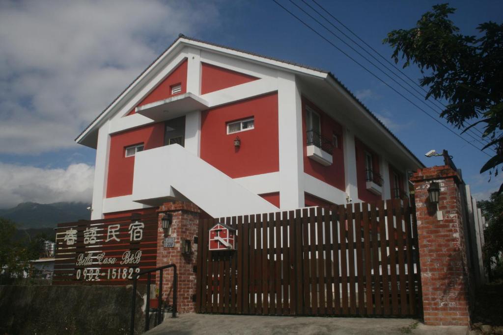 a red and white house with a fence at Bella Casa B&B in Longtian