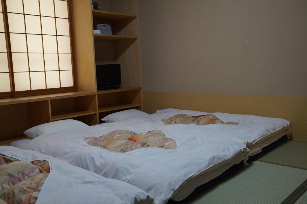 Postel nebo postele na pokoji v ubytování Annex Katsutaro Ryokan