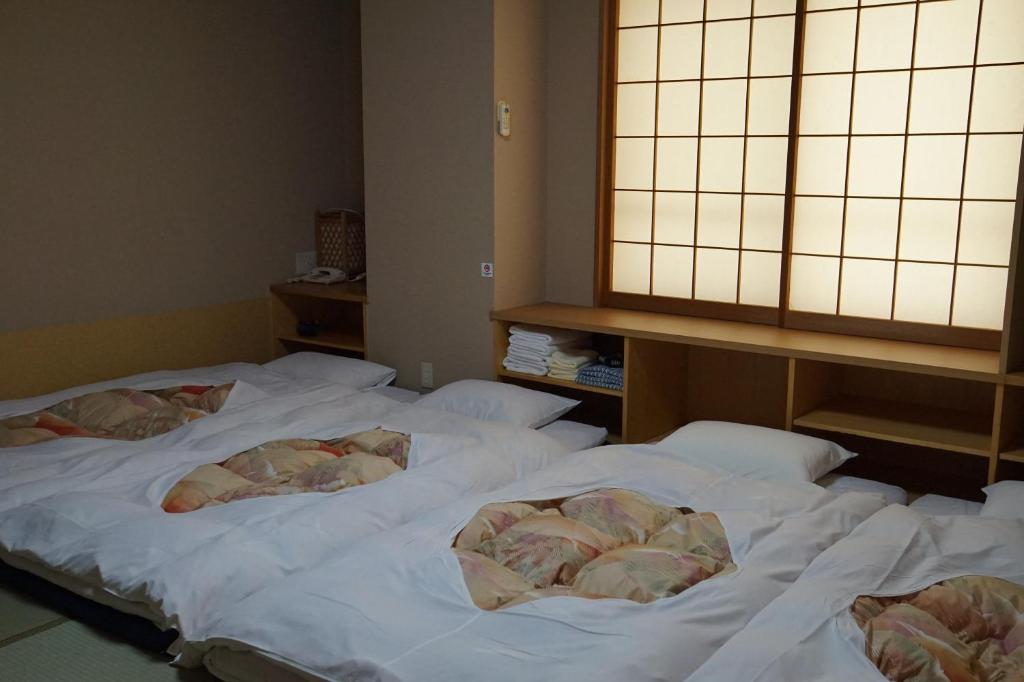 Postel nebo postele na pokoji v ubytování Annex Katsutaro Ryokan