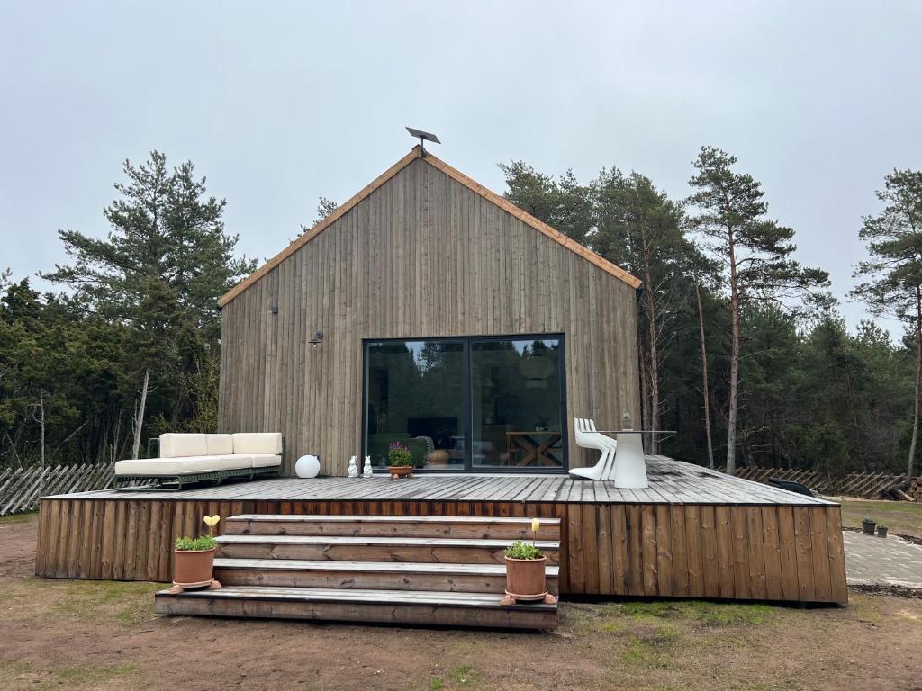 a wooden barn with a large window and a couch at Charming Seaside Country Cottage in Myza Lakhetaguze