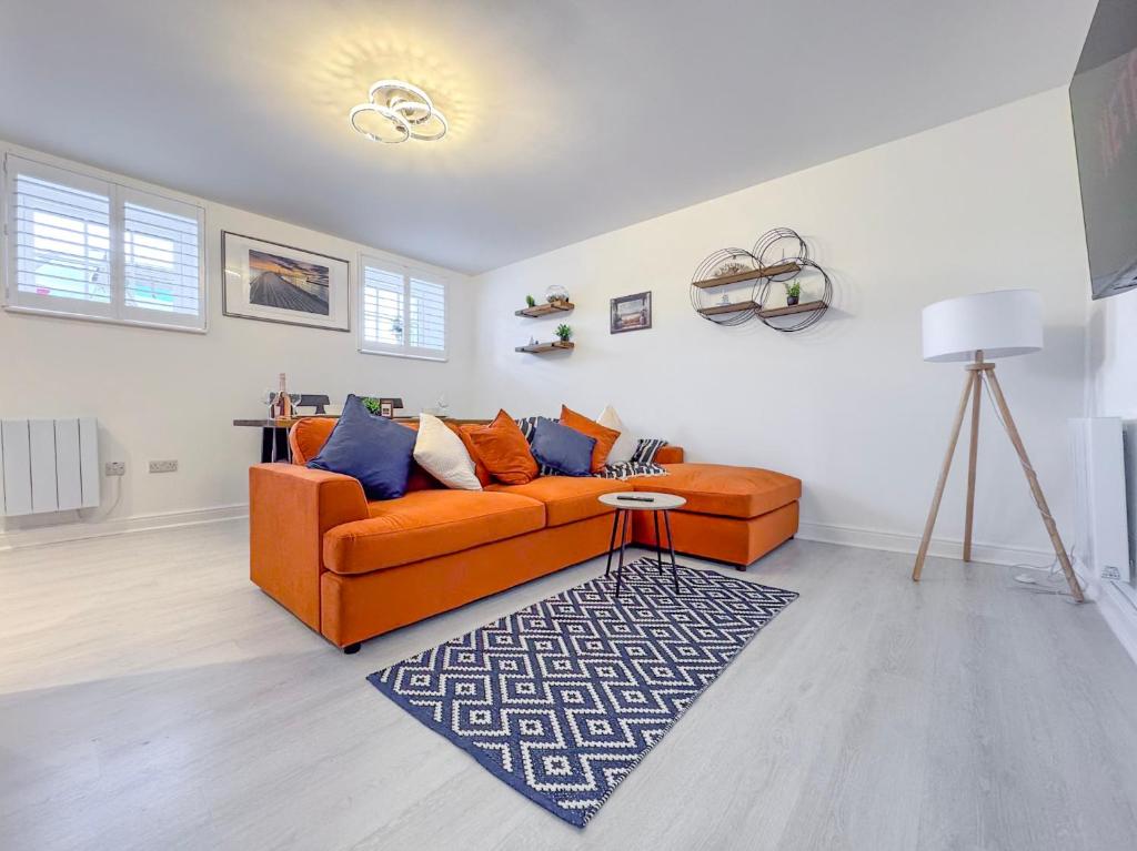 a living room with an orange couch and a rug at The Wee Shore House in Ayr