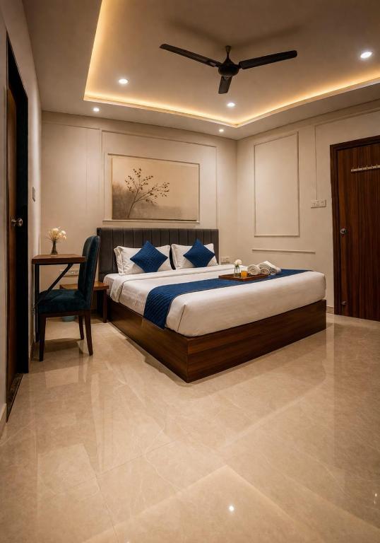 a bedroom with a large bed and a chair at Accuotel Inn RG Grand in Kanāria