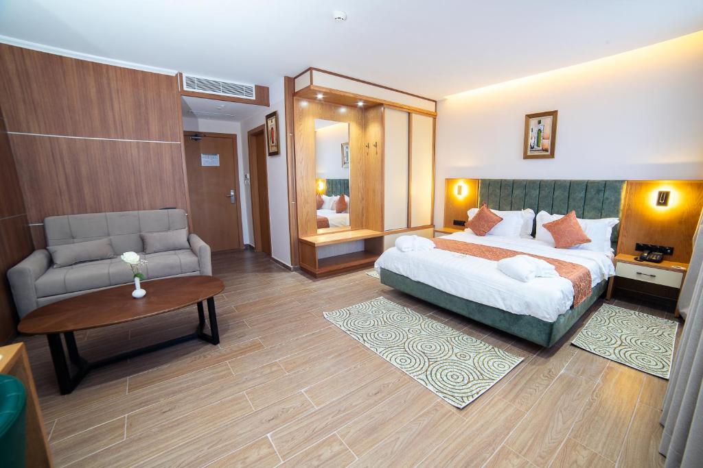 ein Schlafzimmer mit einem Bett, einer Couch und einem Tisch in der Unterkunft Barkat hôtel in Baraki