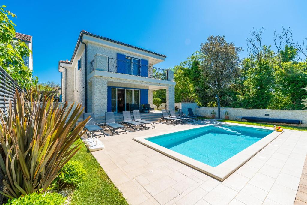 a villa with a swimming pool in front of a house at Modern Villa with Pool and Wellness in Sveti Vid-Miholjice