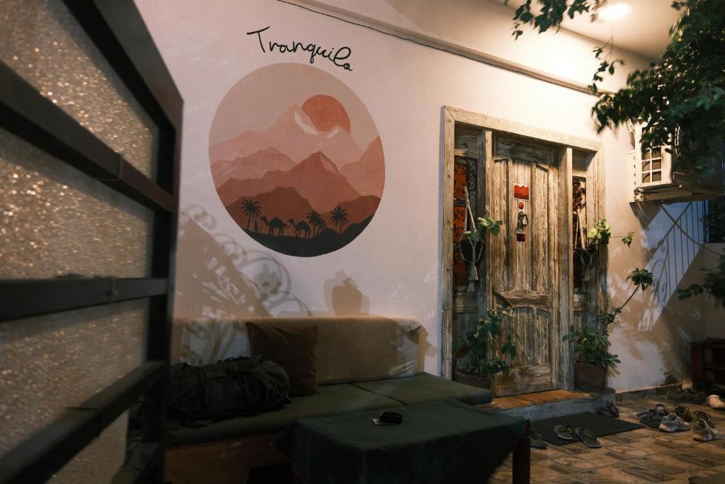 a living room with a couch and a sign on the wall at Tranquilo Boutique Hostel - Dahab in Dahab
