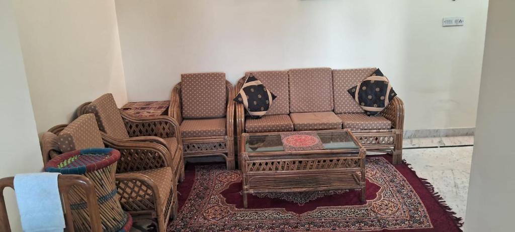 a living room with a couch and chairs on a rug at Sewa Kunj in Mussoorie