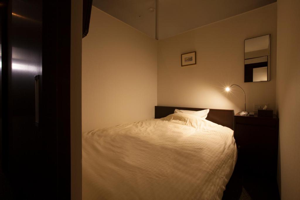 Postel nebo postele na pokoji v ubytování Natural SPA, Kanazawa Hotel Yumenoyu