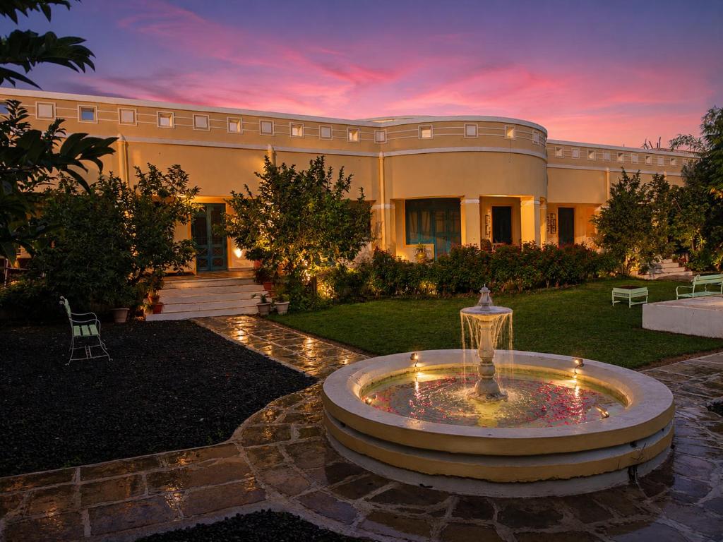 a large house with a fountain in the yard at AM Hotel Kollection- Maangarh, Ratlam in Sailāna