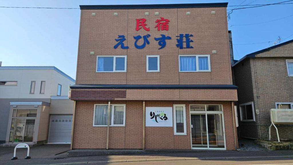a brick building with writing on the side of it at Shimano Yado Rishirikuru in Rishiri