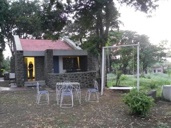 a small house with a table and chairs in front of it at Hotel Kailas in Ellora